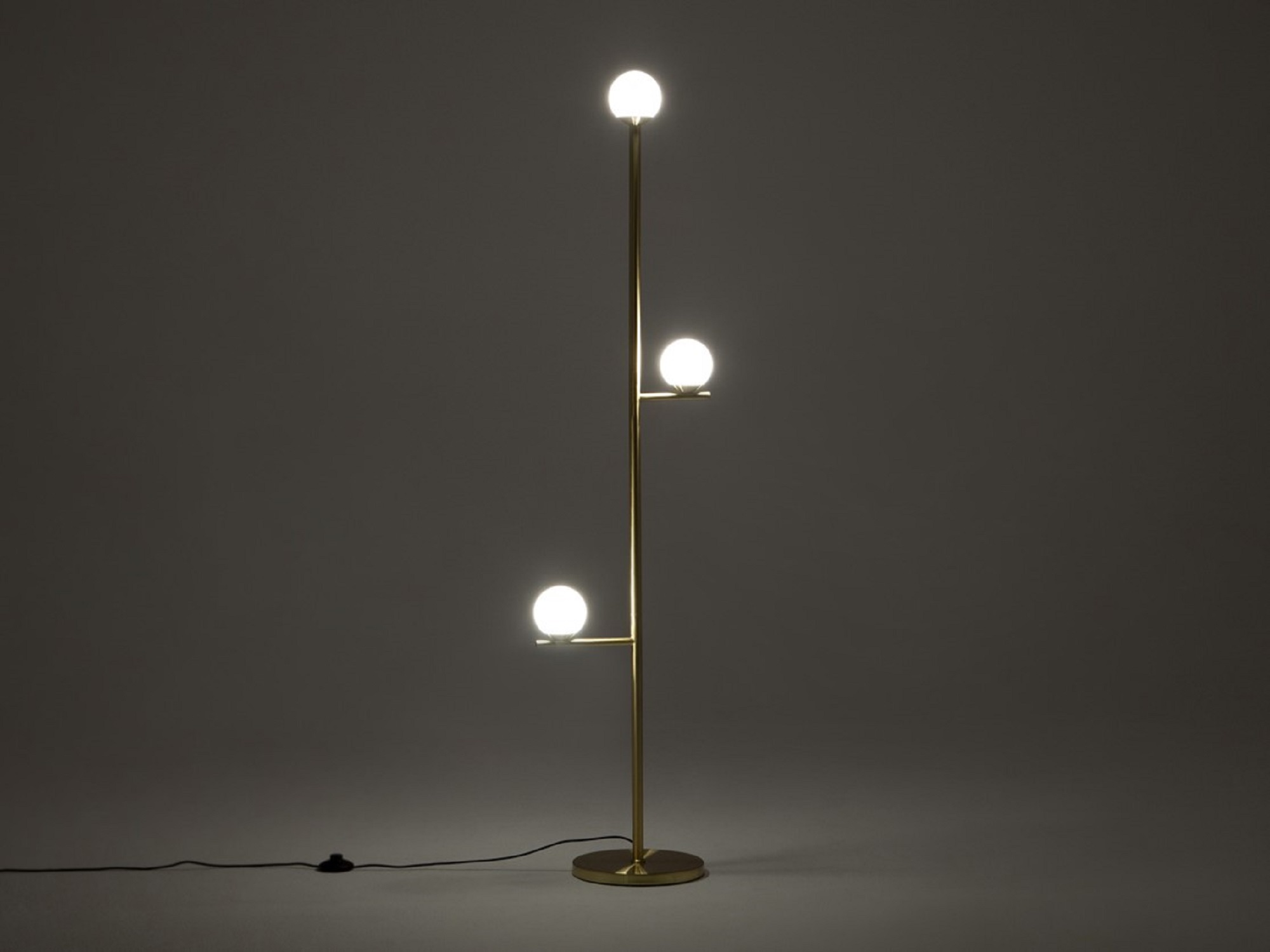 Front view of the Stem mid century floor lamp in black with light on